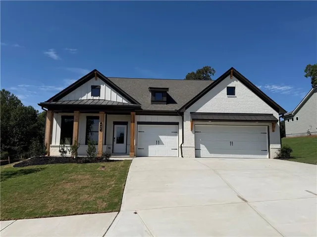 Modern farmhouse-style exterior featuring white vertical siding and painted brick