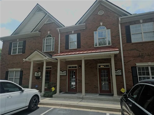 Brick facade building featuring two gabled sections with light trim