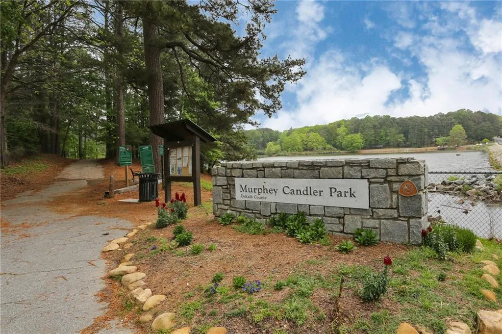 Community / neighborhood sign with a wooded view and a water view