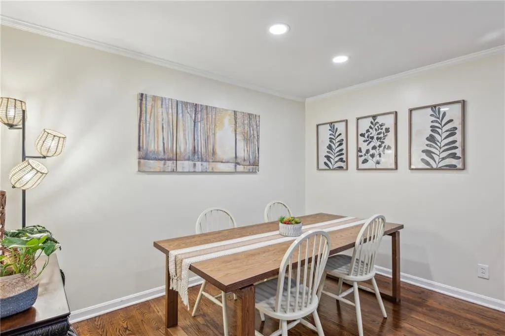 Dining area with crown molding, dark wood floors, and recessed lighting