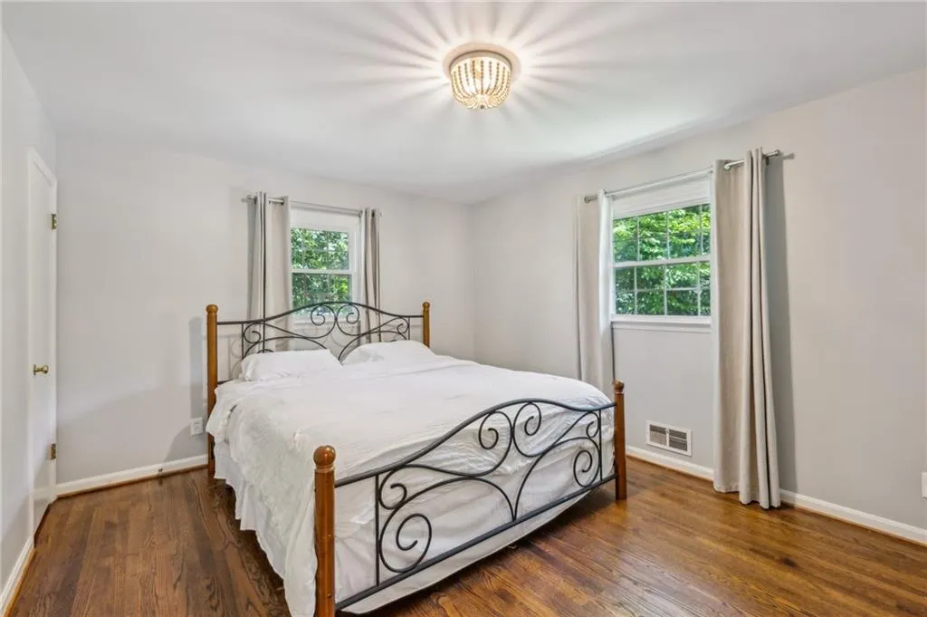 Bedroom featuring multiple windows and dark wood finished floors