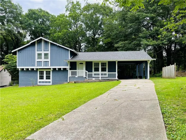 Two-story residence featuring a blue exterior with white trim accents and a gray shingle roof