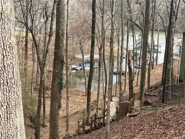 Waterfront access with multiple boat slips, featuring a terraced hillside leading to the water