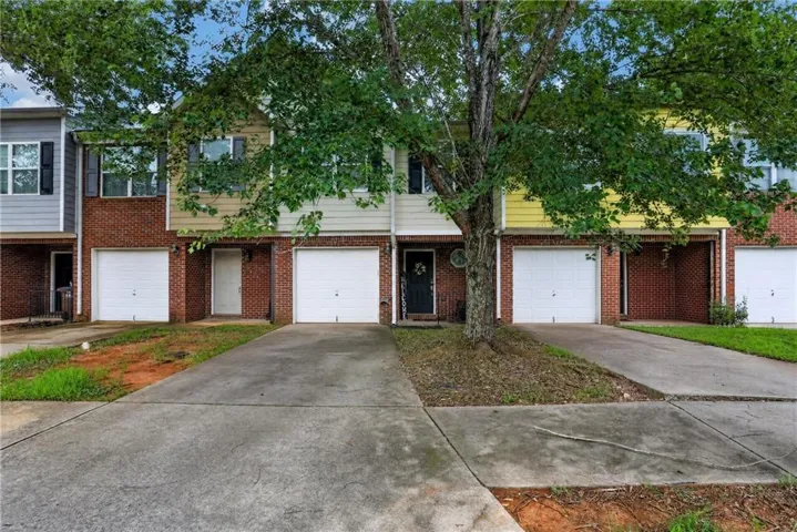 Brick and siding exterior with individual garages and concrete driveways