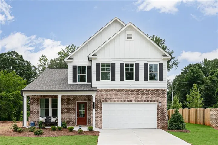 View of front of property with covered porch, board and batten siding, concrete driveway, and an attached garage