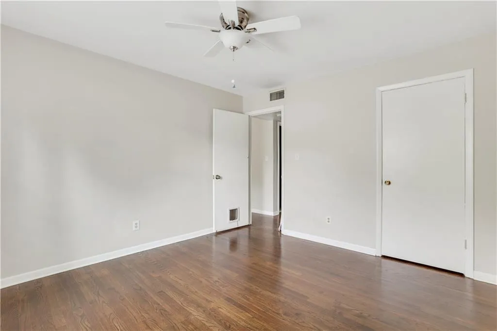 Unfurnished bedroom with wood finished floors, baseboards, and a ceiling fan