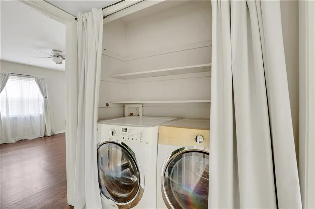 Laundry area featuring independent washer and dryer, wood finished floors, and a ceiling fan