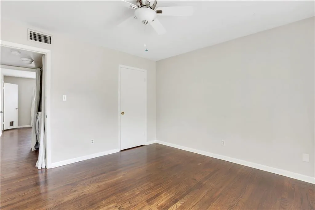 Unfurnished bedroom with dark wood-style flooring, baseboards, and a ceiling fan