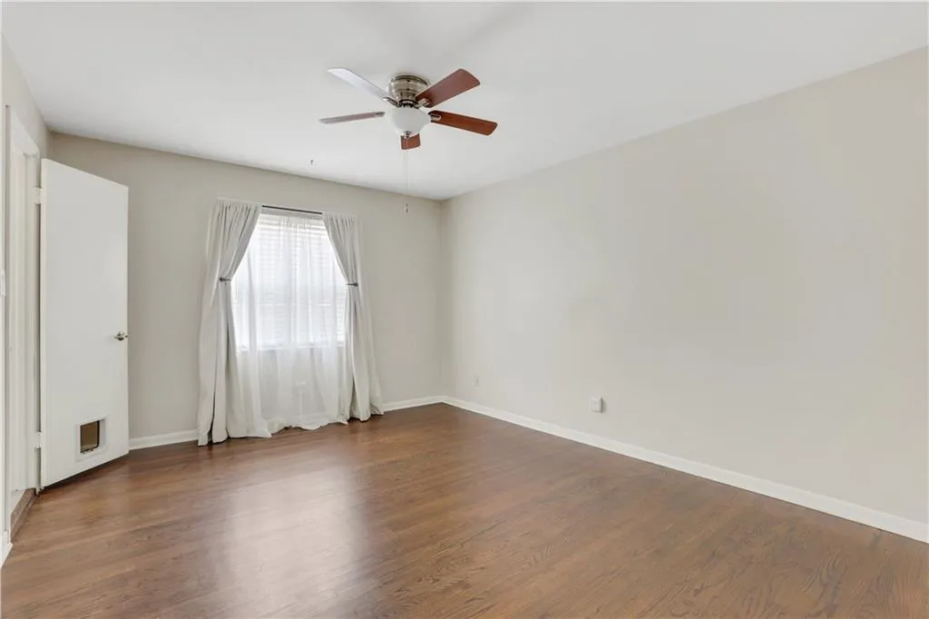 Spare room featuring ceiling fan, dark wood-type flooring, and baseboards