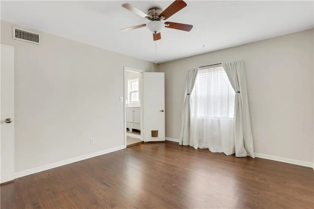 Unfurnished room with ceiling fan, baseboards, and wood finished floors