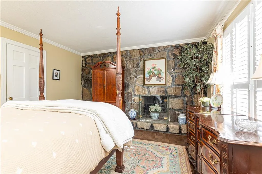 Full granite wall with cozy fireplace adds intimate charm in the primary suite.