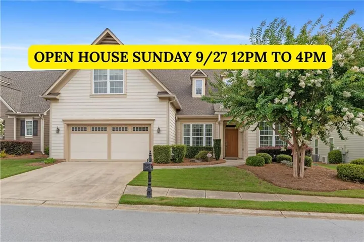 Two-car garage with paneling, dormer window, gabled roof, and mature landscaping