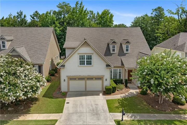 Two-story residence featuring dormer windows, a two-car garage, and a concrete driveway