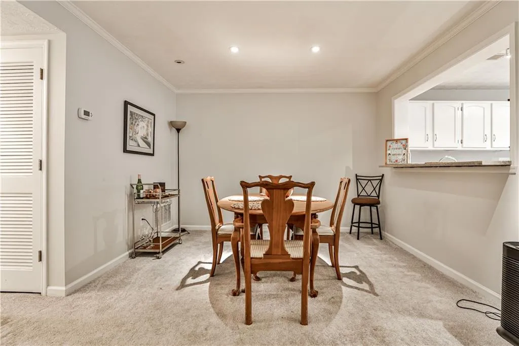 Dining room with crown molding, light carpet, and recessed lighting