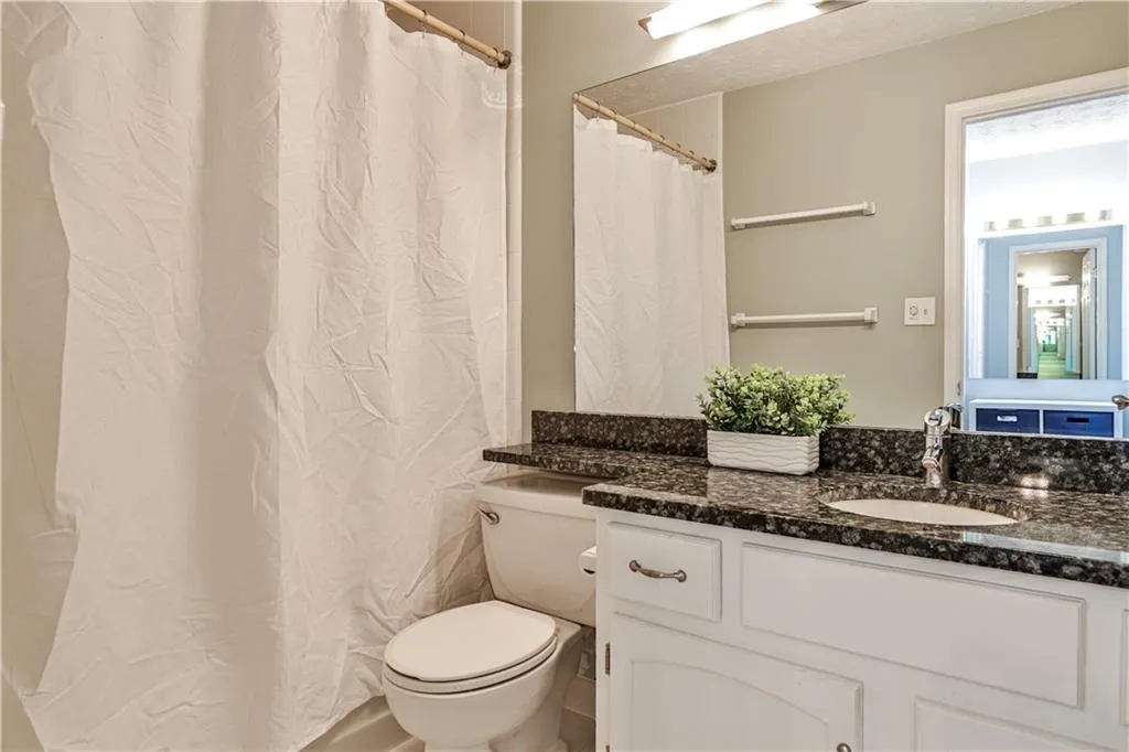 Bathroom featuring a shower with shower curtain and vanity