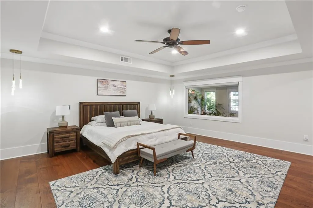 Terrace level ray ceiling with recessed lighting, wood-finish flooring, ceiling fan, and a large window
