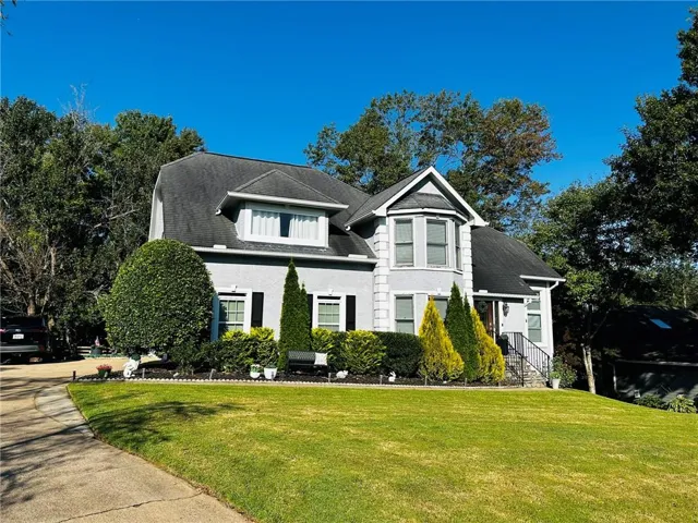 Two-story exterior with a bay window, dormer window, and dark shutters