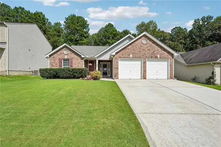 Brick and siding exterior with a two-car garage, concrete driveway, and front lawn