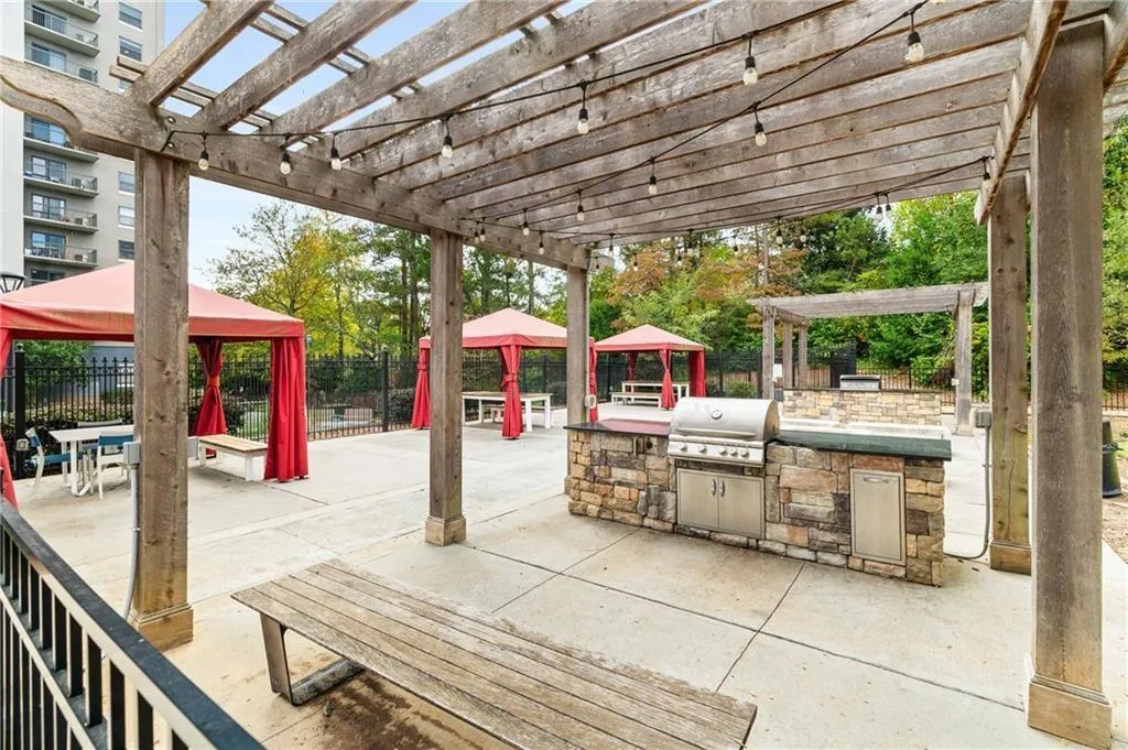 Community outdoor area with three covered seating areas, twos grills under pergolas, and an outdoor fire pit