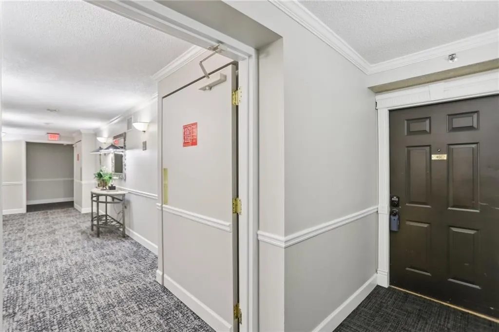 Foyer entrance featuring ornamental molding, carpet flooring, and a textured ceiling