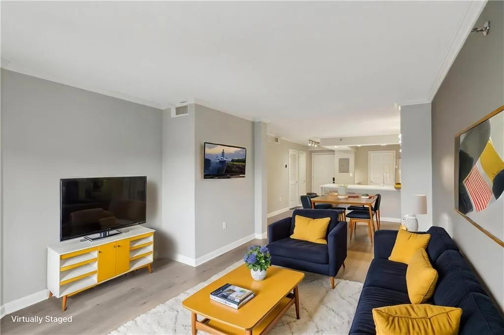 Living room featuring crown molding and light hardwood / wood-style floors