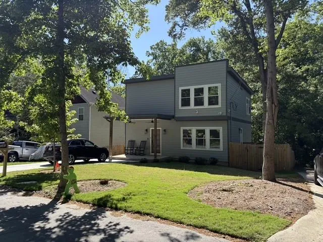 Contemporary two-story residence featuring light gray siding and white trim