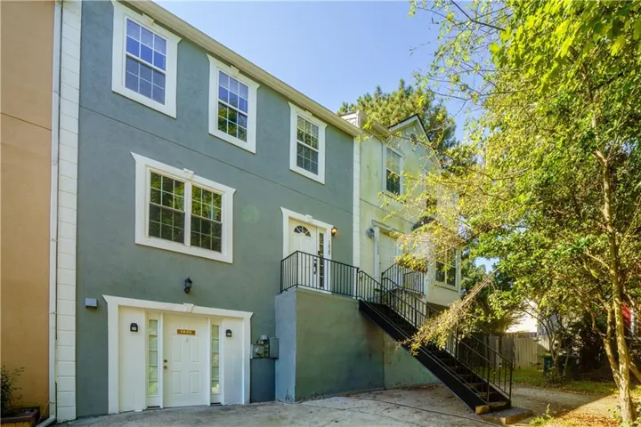 Stucco exterior with multiple windows, prominent entry door, and a built-in garage with an additional access door