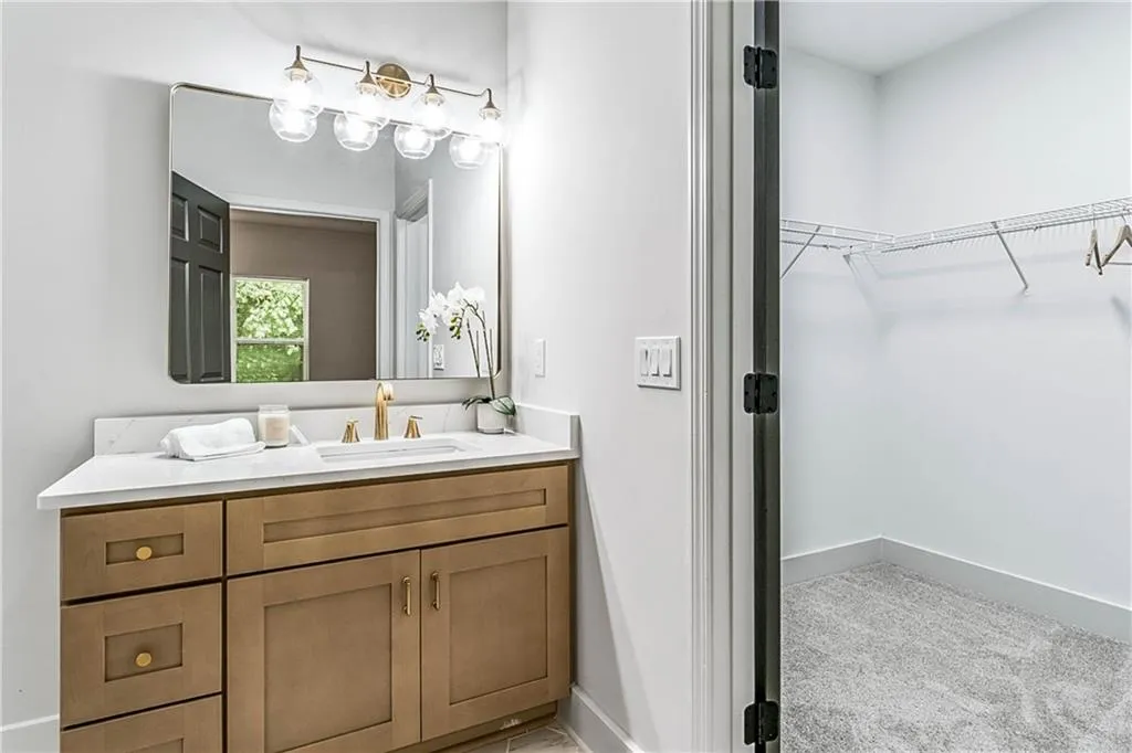 Full bath featuring vanity and a spacious closet