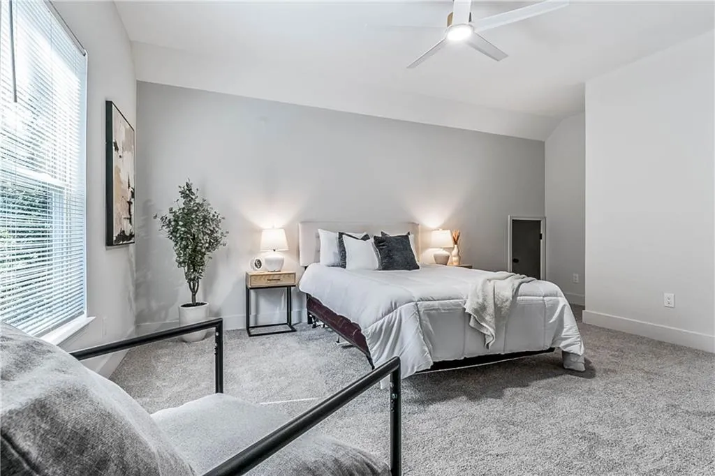 Carpeted bedroom featuring a ceiling fan and baseboards