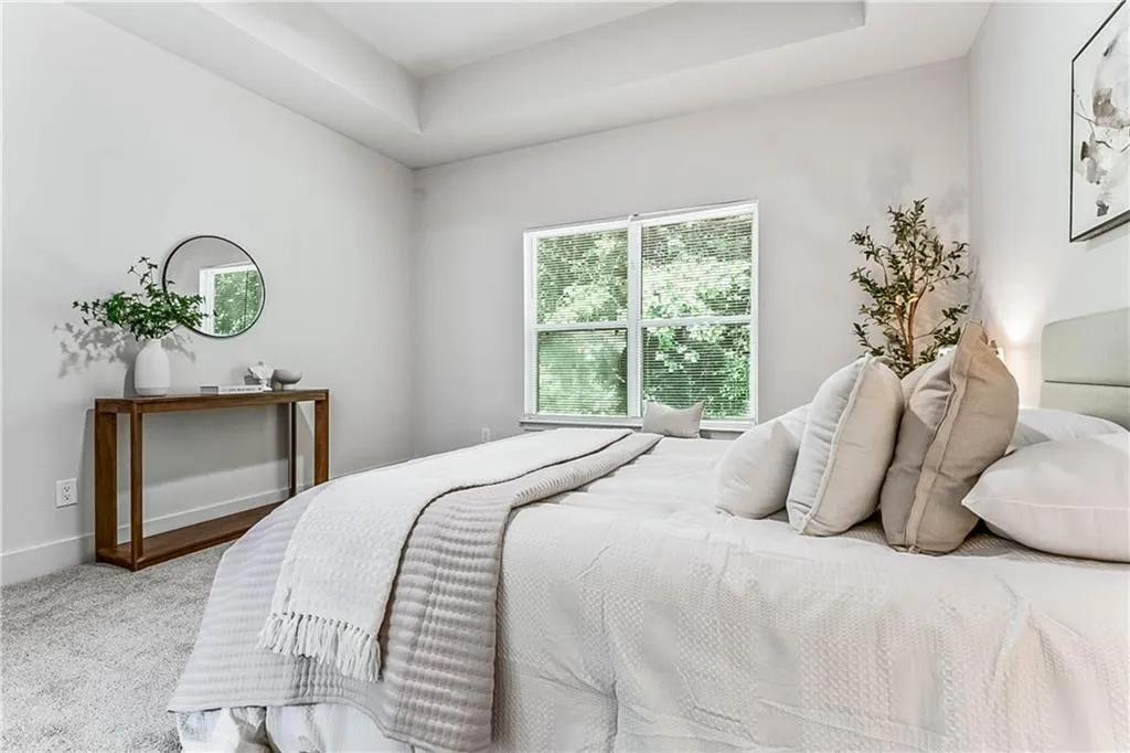 Bedroom featuring carpet and a raised ceiling