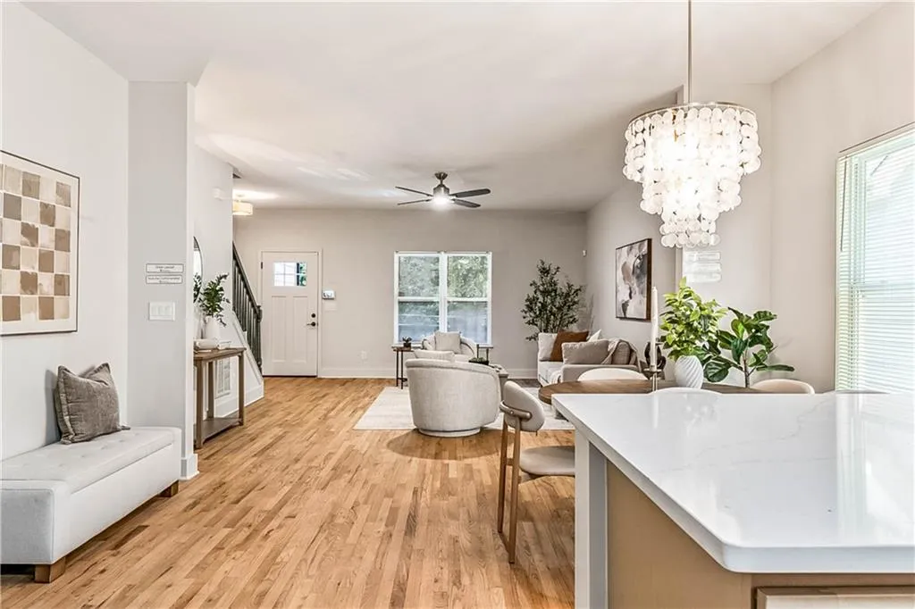 Dining room with a chandelier, light wood finished floors, a ceiling fan, and stairway