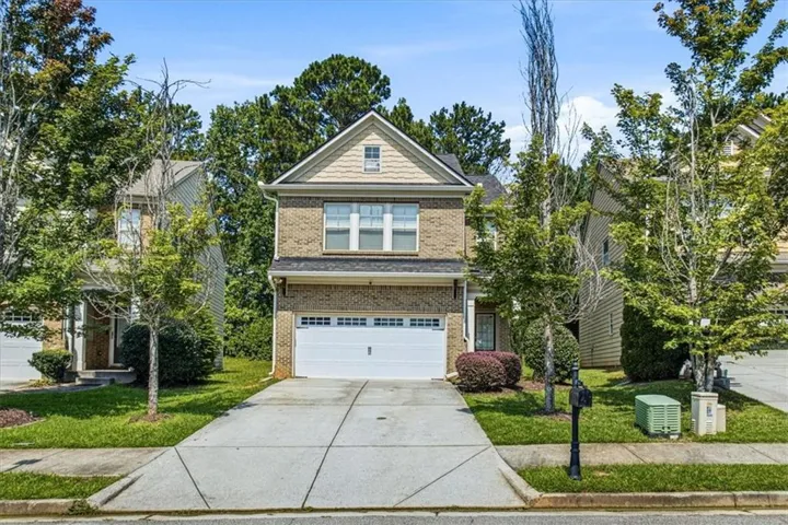 Two-story brick and siding construction featuring a prominent front-facing gable, a double-width driveway, and an integrated garage