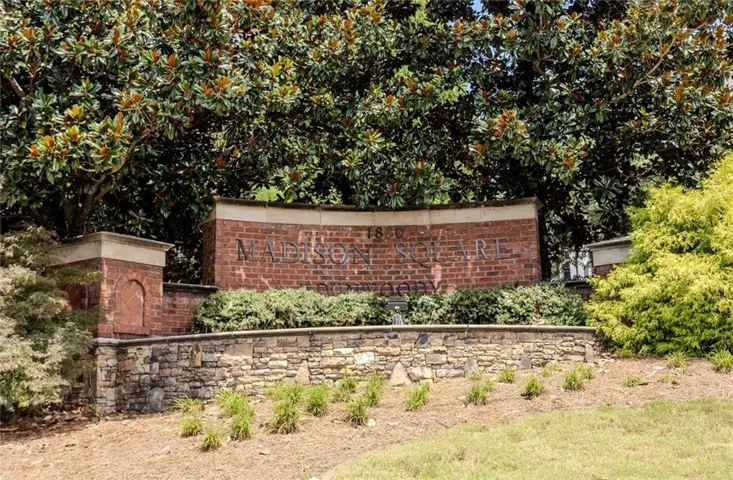 Brick and stone entry monument with mature landscaping