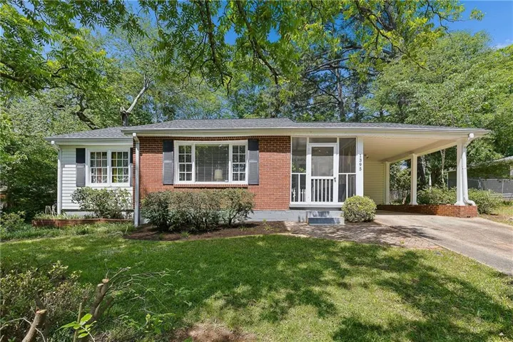Brick and siding facade, covered carport, screened entry, front landscaping, and an concrete driveway