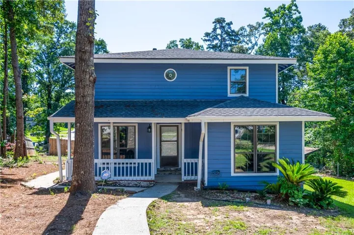 Two-story residence featuring blue siding, white trim, and a covered front porch with white railings