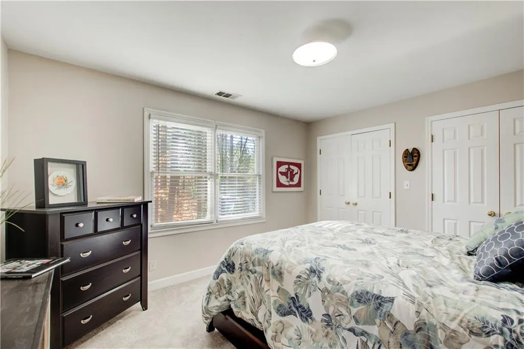 Bedroom featuring light colored carpet and two closets