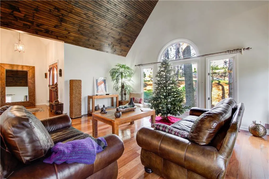 Living area featuring high vaulted ceiling, wood finished floors, and wood ceiling