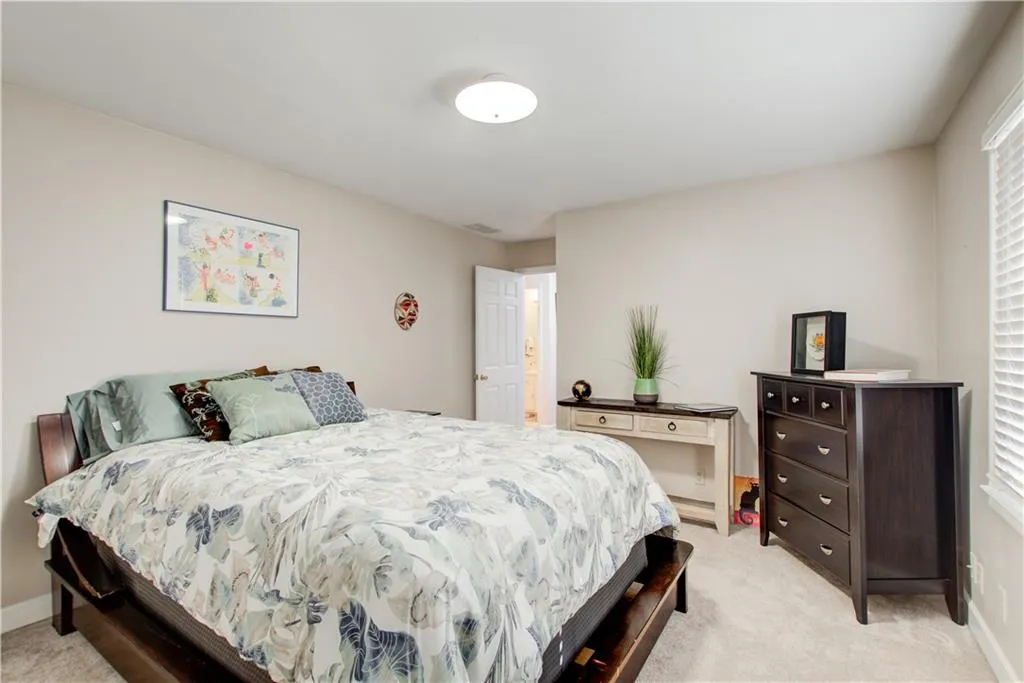 Bedroom with light colored carpet and baseboards