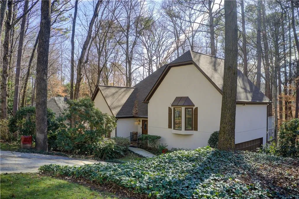 View of front facade with a shingled roof and stucco siding