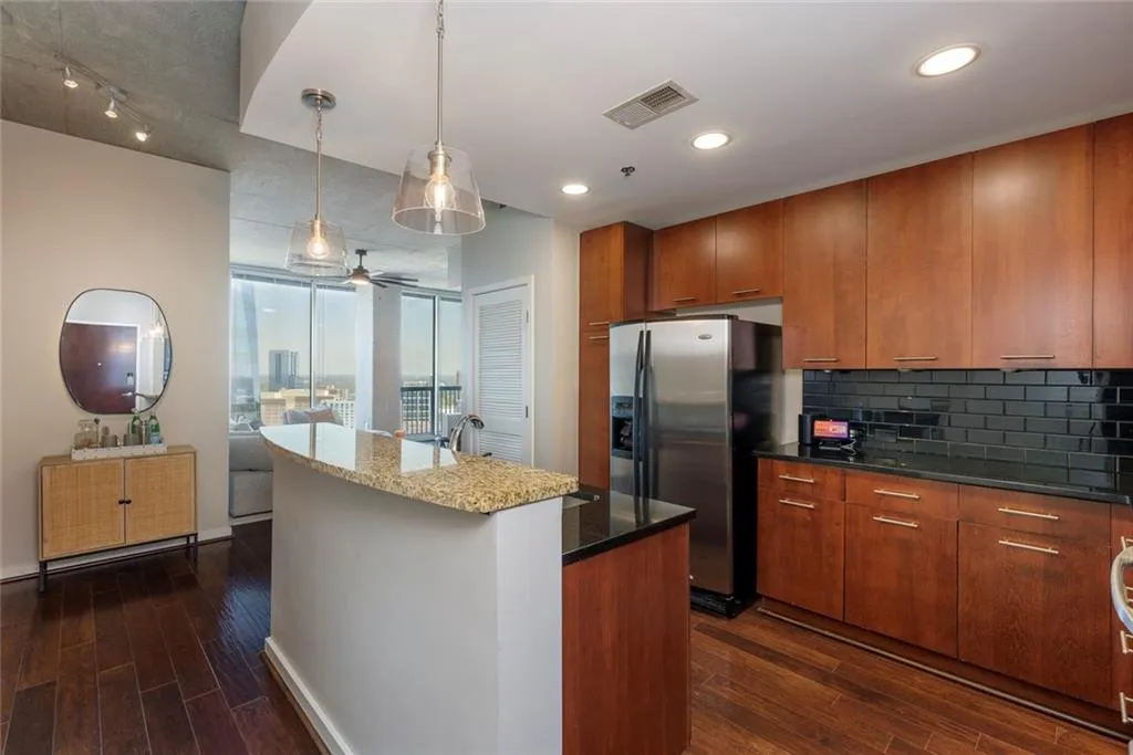 Kitchen with stainless steel appliances, kitchen island, and stone countertops.