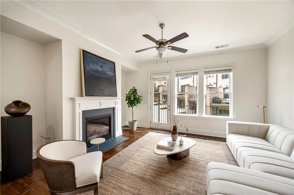 Living room with a fireplace with flush hearth, visible vents, baseboards, dark wood finished floors, and crown molding