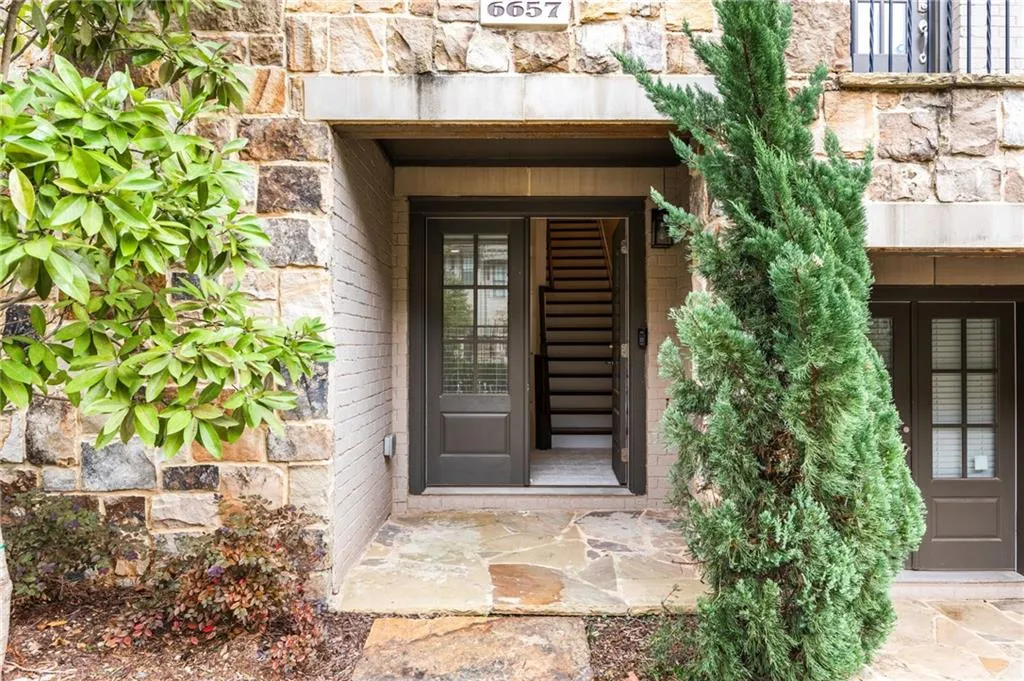 Doorway to property with stone siding and brick siding