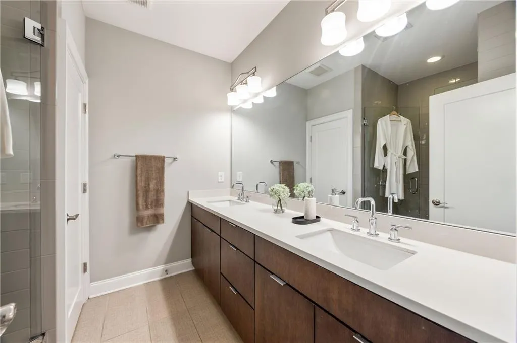 Full bath featuring baseboards, a sink, visible vents, and a shower stall