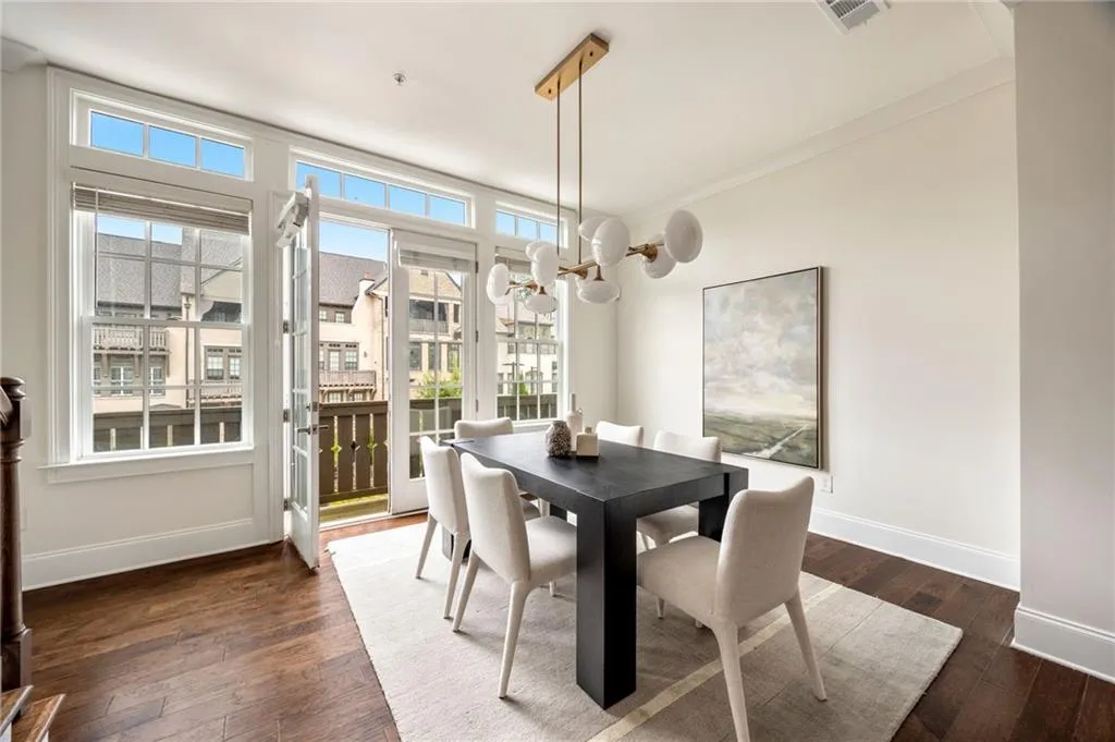 Dining area featuring dark wood-style floors, baseboards, visible vents, and an inviting chandelier