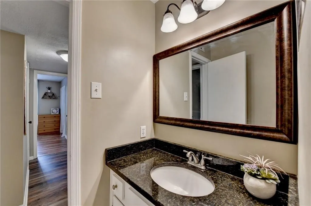 Bathroom featuring wood finished floors, vanity, and a chandelier