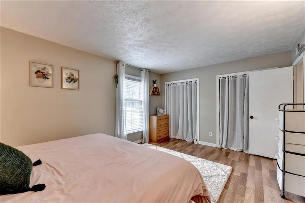 Bedroom featuring wood finished floors, a textured ceiling, and baseboards