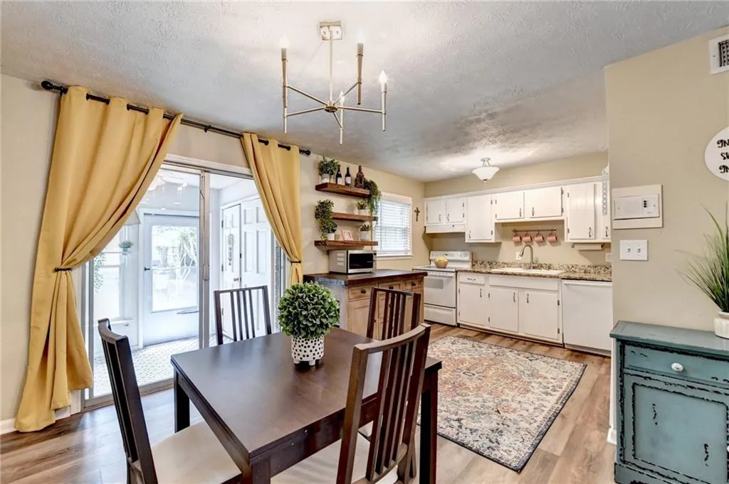Dining room with a chandelier, a textured ceiling, and light wood-type flooring