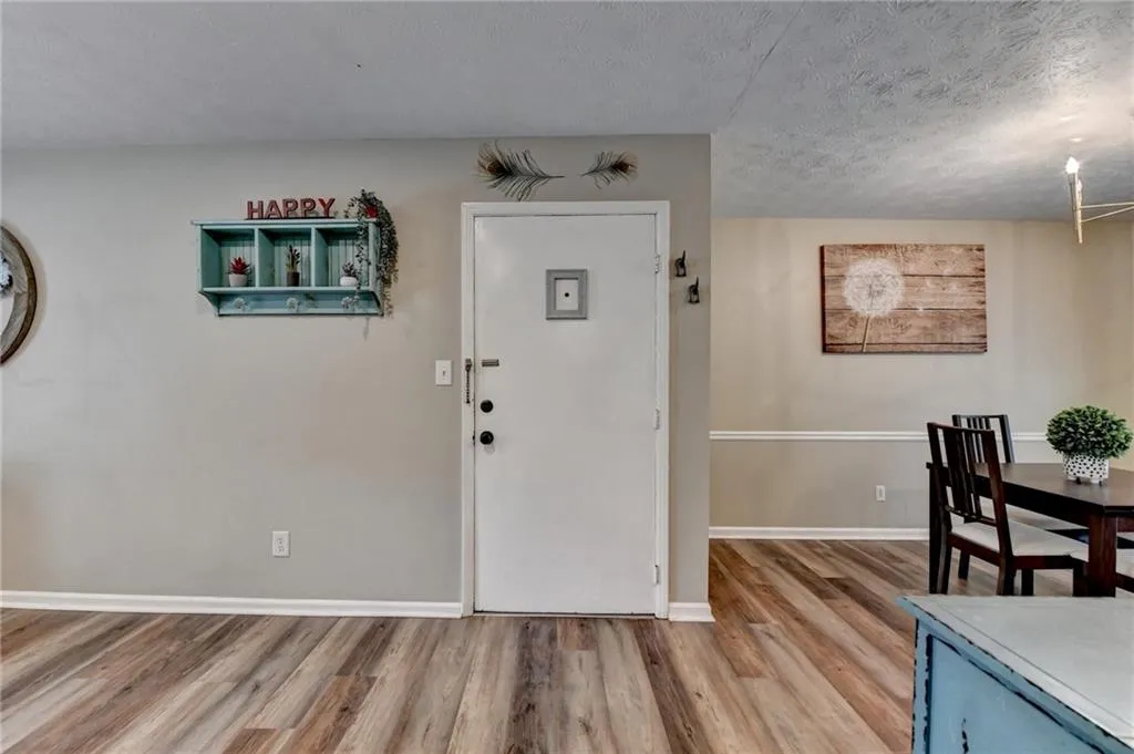 Foyer featuring wood finished floors, a textured ceiling, and baseboards