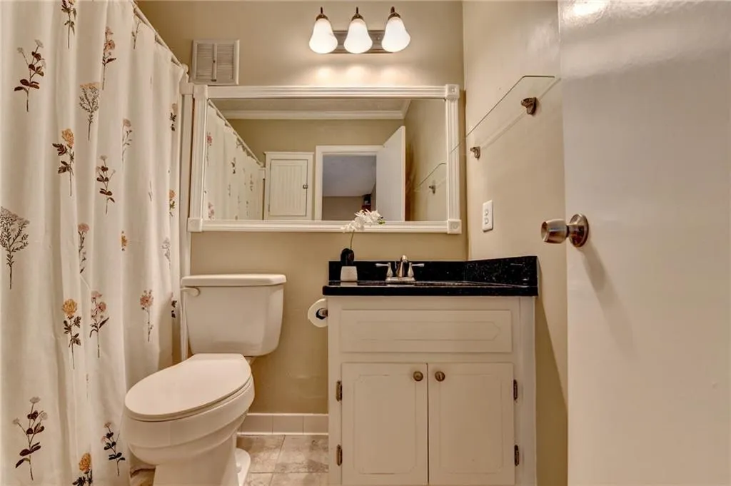 Bathroom featuring baseboards, toilet, and vanity