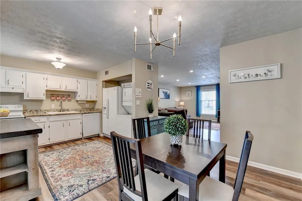 Dining area featuring a textured ceiling, light wood-style flooring, baseboards, a chandelier, and recessed lighting